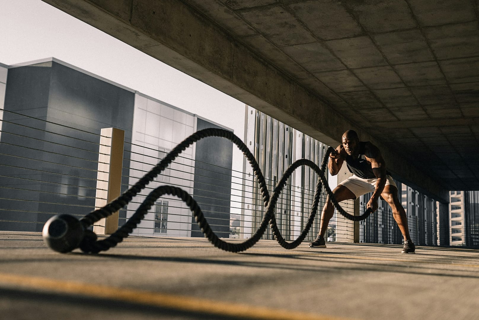 Man building strength with battle ropes during an intense workout, symbolizing resilience and overcoming challenges.