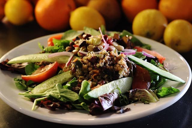 A wholesome and colorful quinoa bowl with fresh vegetables, herbs, and a plant-based dressing, perfect for a nourishing meal.