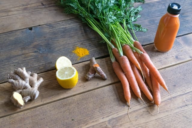 A refreshing ginger shot made with fresh ginger, turmeric, carrot, lemon, and a bottle of ginger juice, ideal for boosting energy and immunity.