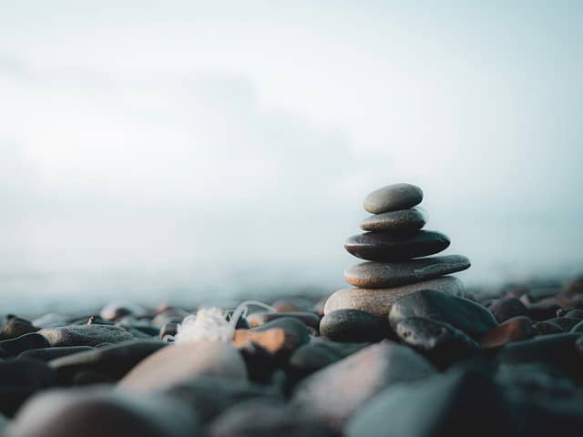 Calm, smooth rocks placed neatly on a tranquil beach, symbolizing peace and balance